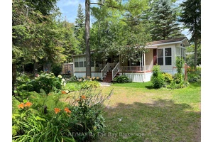 This charming, 3 bedroom seasonal cottage is nestled in lush greenery within the beautiful Wasaga Country Life Resort, offering a serene retreat with a lovely porch and vibrant garden.