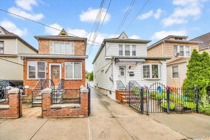 American foursquare style home with brick siding, a fenced front yard, and a gate