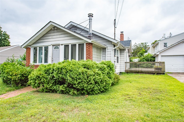 View of home's exterior featuring a chimney, a lawn, and brick siding