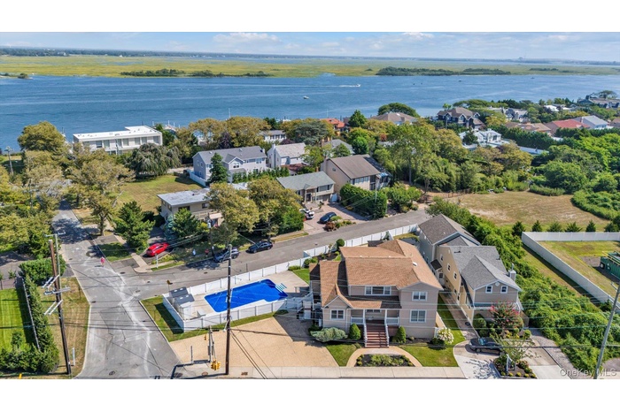 Aerial perspective of suburban area featuring a large body of water