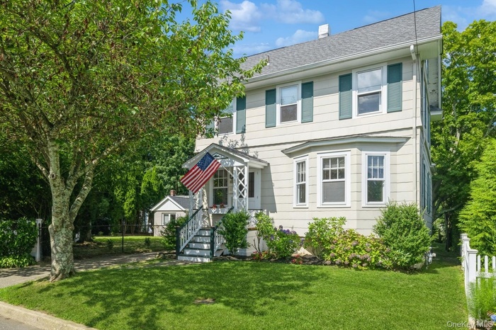 Colonial inspired home with a chimney and roof with shingles