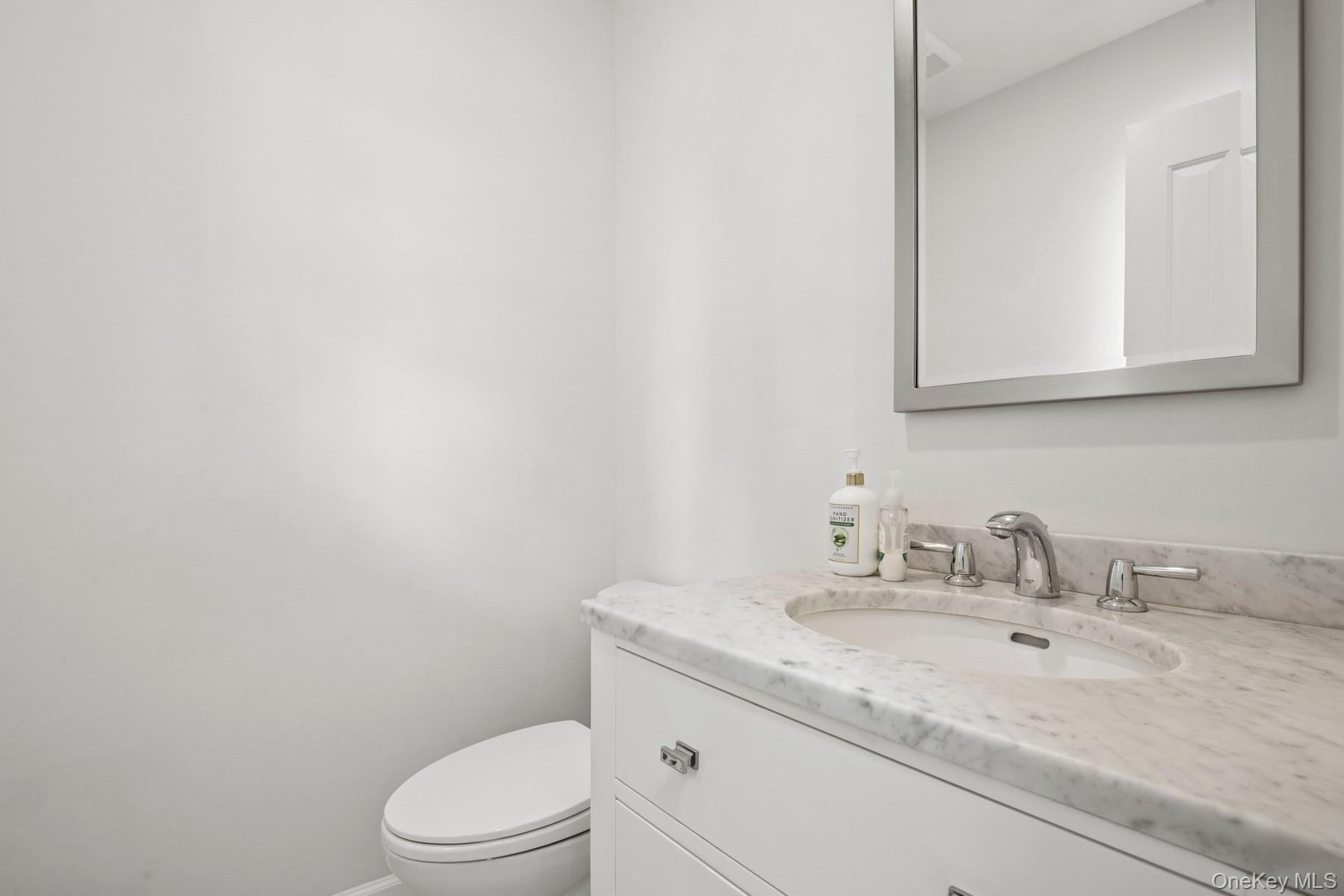 Bathroom featuring toilet, vanity, and baseboards
