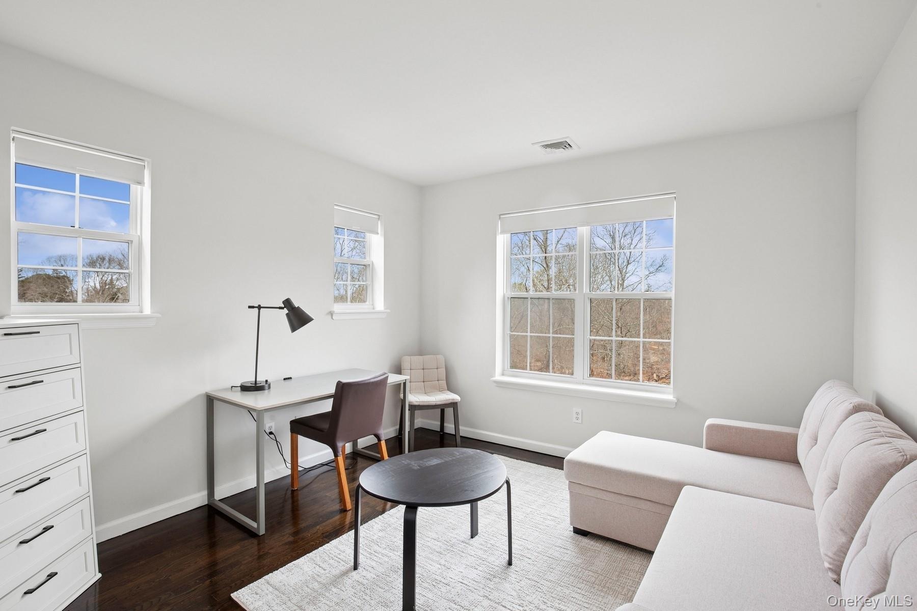Office area featuring visible vents, baseboards, and dark wood-style floors