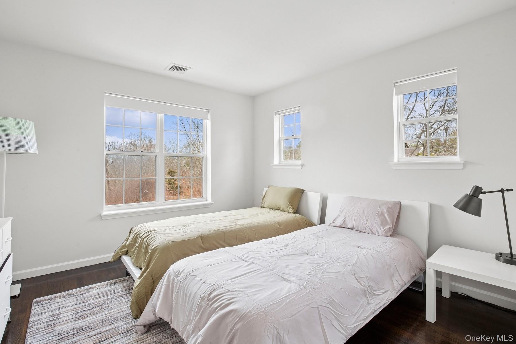 Bedroom with visible vents, baseboards, and dark wood finished floors