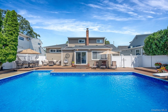 View of pool featuring a deck, a fenced backyard, and outdoor dining area