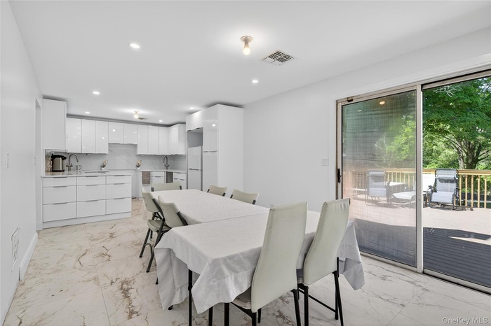 Dining room featuring light marble finish floors and recessed lighting