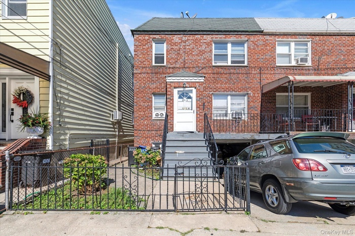 View of front of property with brick siding, a gate, and a fenced front yard