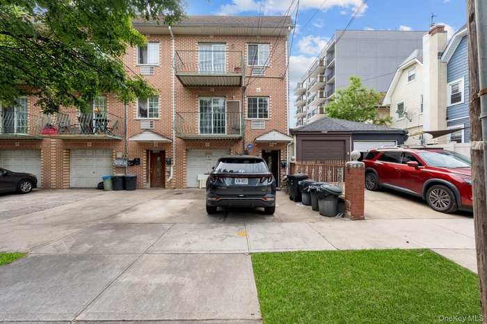 Traditional home with brick siding, concrete driveway, an attached garage, and a balcony