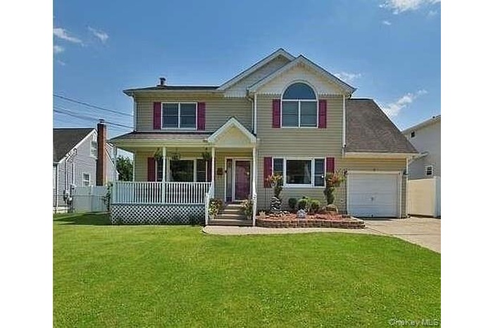 View of front of property with a porch, an attached garage, and concrete driveway