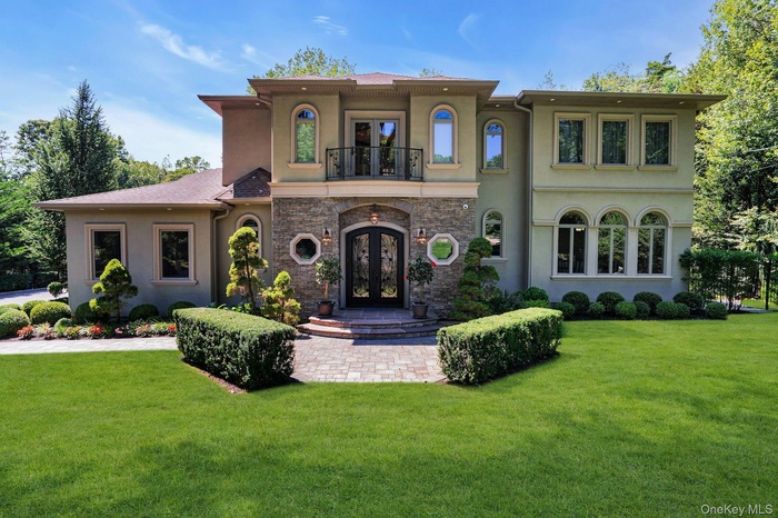 Mediterranean / spanish home featuring french doors, a balcony, stucco siding, stone siding, and a front yard