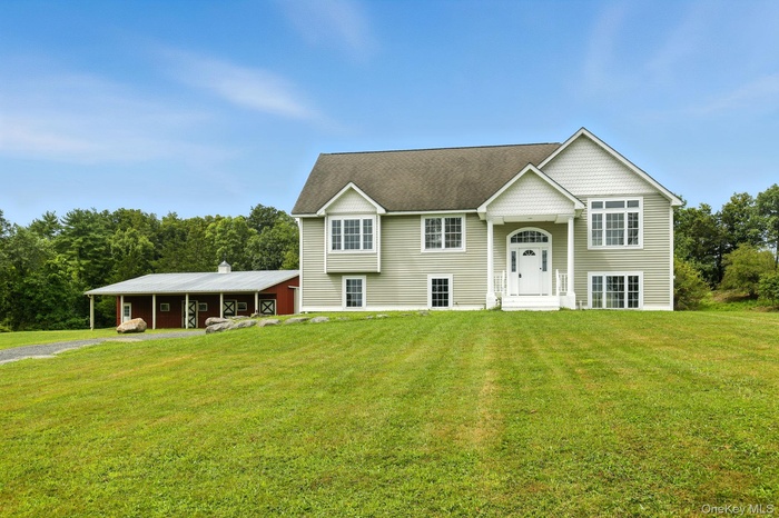 Bi-level home with a front yard and roof with shingles