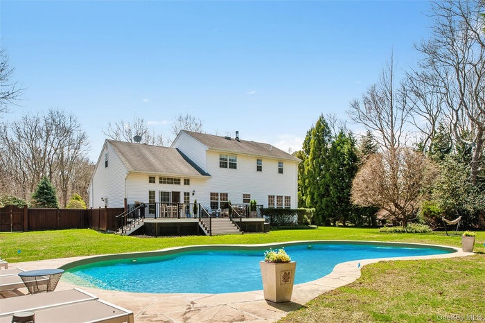 View of swimming pool featuring a lawn, stairs, a wooden deck, a fenced in pool, and fence private yard