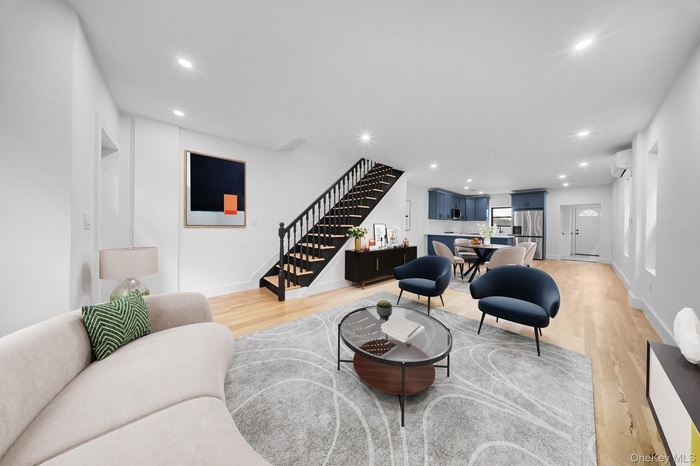 Living area featuring stairway, recessed lighting, light wood-type flooring, and a wall mounted air conditioner