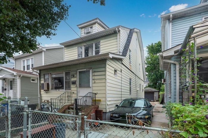 View of front of property with a gate and a detached garage