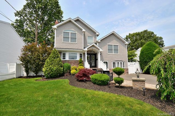View of front of home with stone siding and a chimney