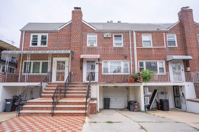 Traditional-style home featuring brick siding, an attached garage, a chimney, and concrete driveway