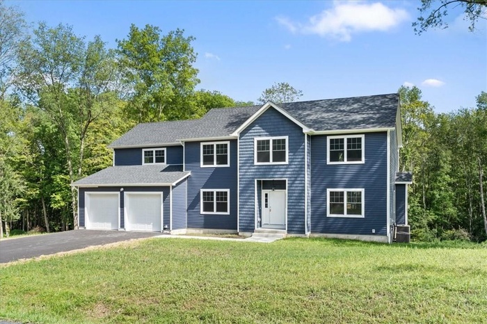 View of front of home with a garage and a front yard
