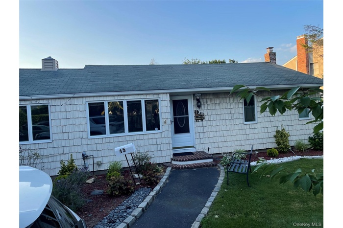 View of front of house with a chimney, a shingled roof, and a front yard