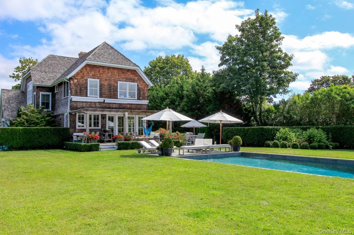 Back of property with a fenced in pool, a yard, and a patio area