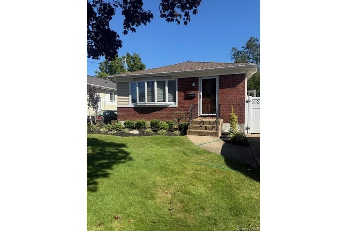 Bungalow featuring entry steps and brick siding