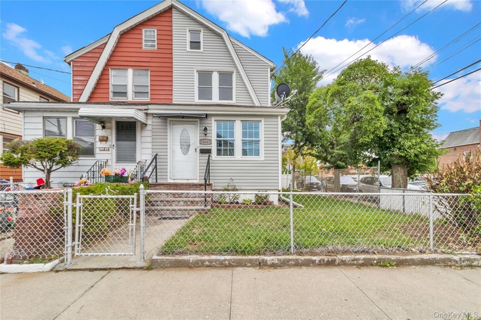 Colonial inspired home featuring a gate, a gambrel roof, and a fenced front yard