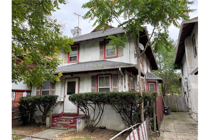 View of front facade featuring a shingled roof, stucco siding