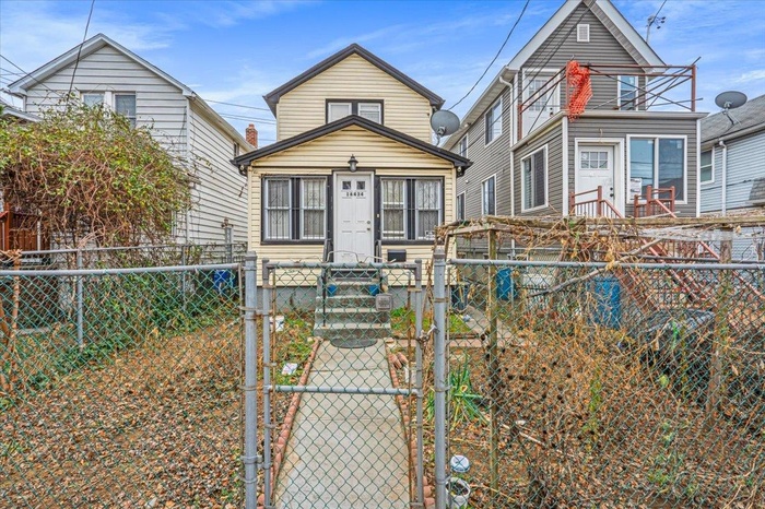 Shotgun-style home featuring a fenced front yard and a gate