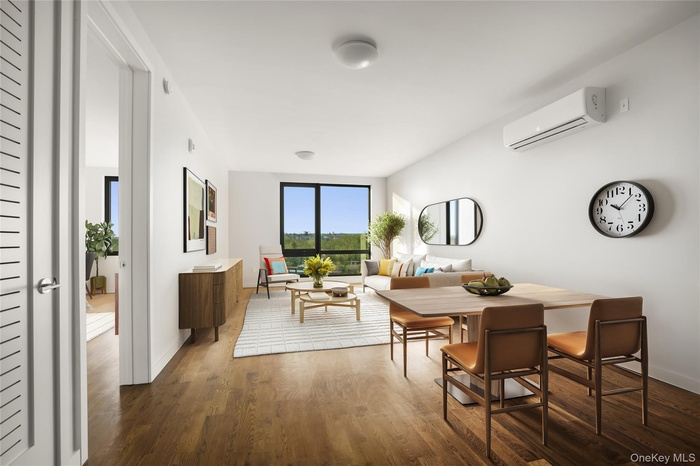 Dining area with a wall unit AC, dark wood-type flooring, and baseboards