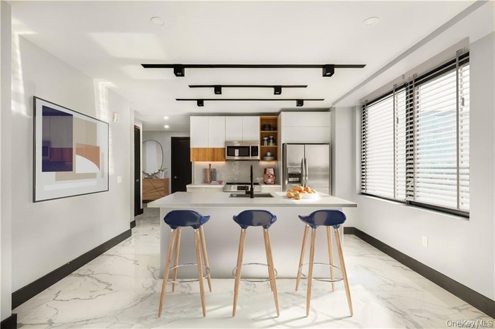 Kitchen with light countertops, marble finish floor, stainless steel appliances, and modern cabinets