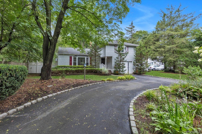 Traditional-style home featuring a garage and asphalt driveway
