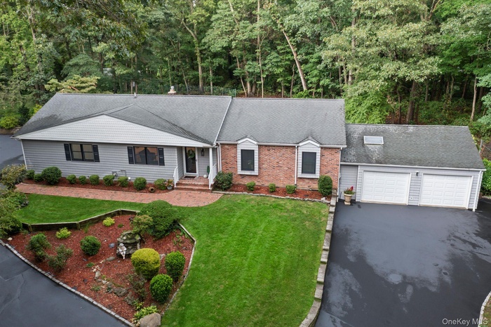 Ranch-style house with a garage, aphalt driveway, a shingled roof, and a front yard