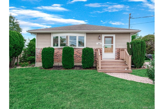 View of front of house featuring a front lawn and brick siding