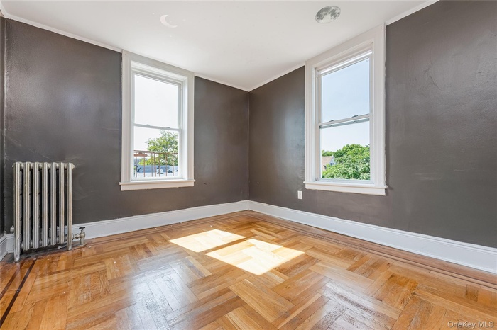 Spare room featuring radiator heating unit and plenty of natural light