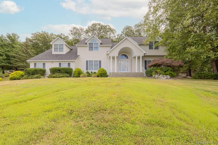 Colonial-style house featuring a front lawn