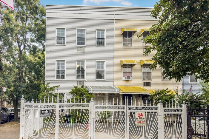 View of front of property with a gate, a fenced front yard, and cooling unit