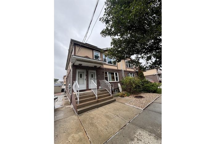 View of front of home featuring covered porch and brick siding