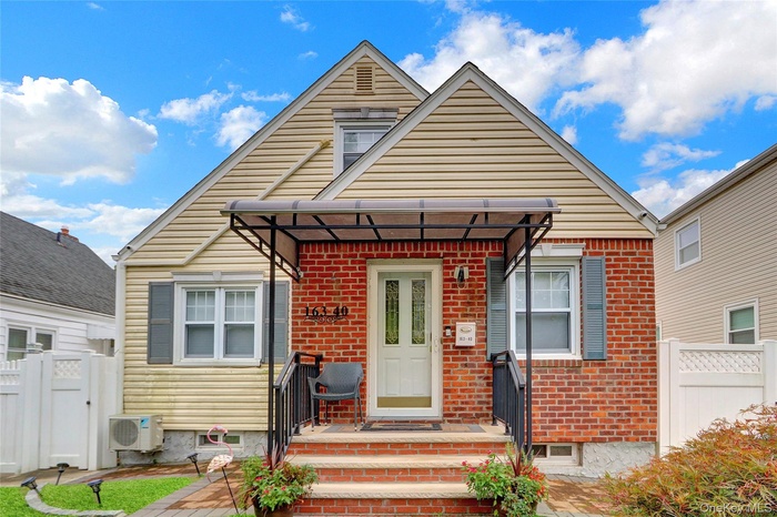 Bungalow-style home featuring brick siding and a gate