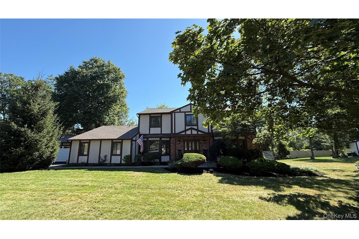 Tudor-style house with a shingled roof and brick siding