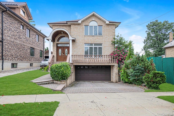 View of front of property with brick siding, concrete driveway, a garage, and a front yard