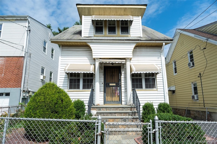 View of front of home featuring a gate, a fenced front yard, a garage, a shingled roof, and cooling unit