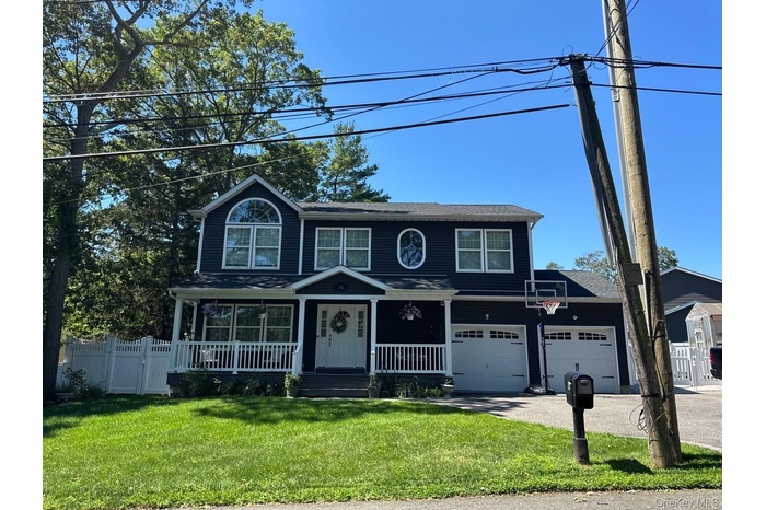 Traditional home featuring a porch, driveway, and a gate