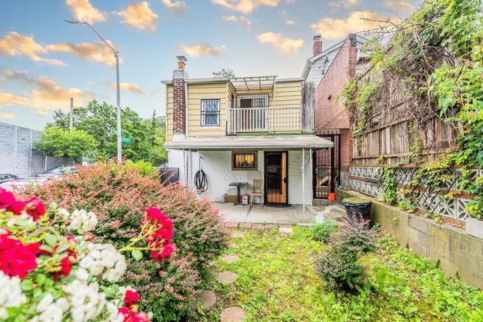 Rear view of house with a balcony, a patio, stucco siding, and a chimney