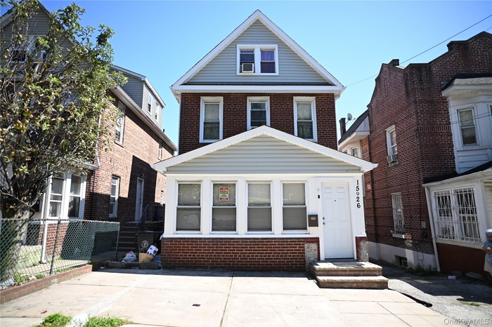 American foursquare style home featuring brick siding