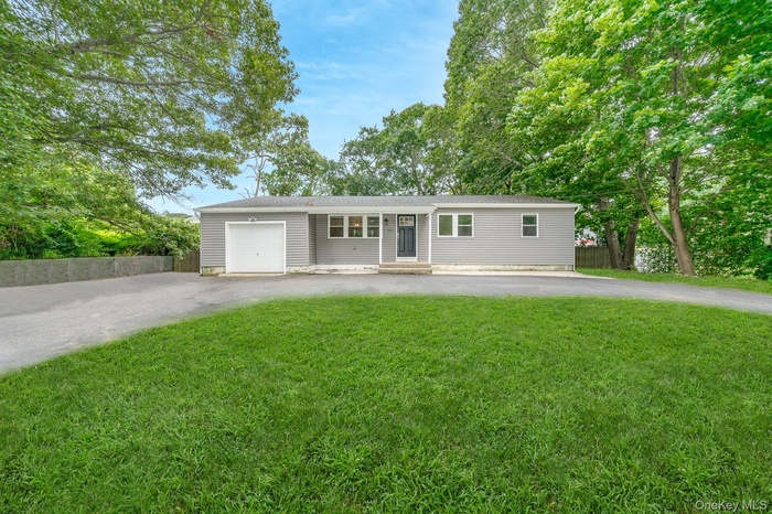 Ranch-style house featuring driveway and a garage