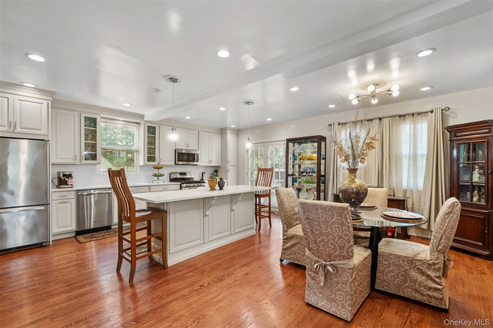 Dining space with recessed lighting, wood finished floors, and a chandelier