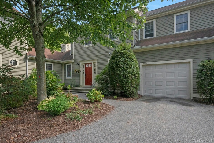 Traditional-style house featuring a garage and asphalt driveway