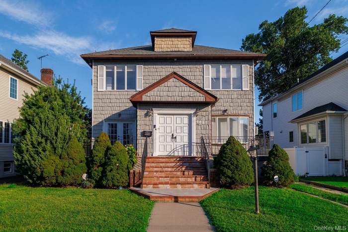 American foursquare style home featuring a front yard