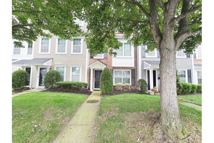 View of front of property featuring brick siding and a front yard
