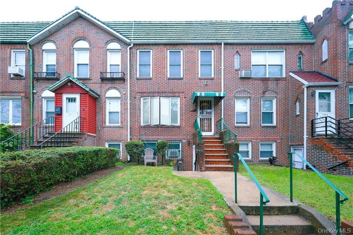 View of front facade featuring a front yard and brick siding