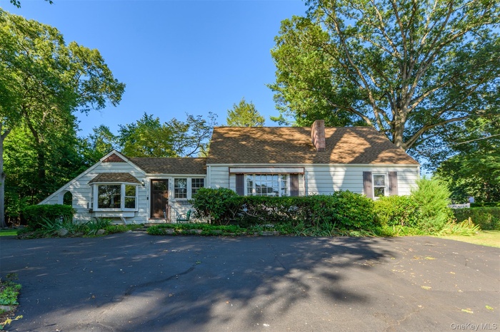Cape cod house featuring a chimney
